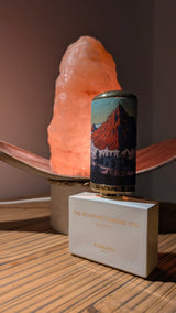Flacon de parfum TIARA FLORAÏKU The Mountain Standing Still avec capot illustré devant une lampe en sel rose